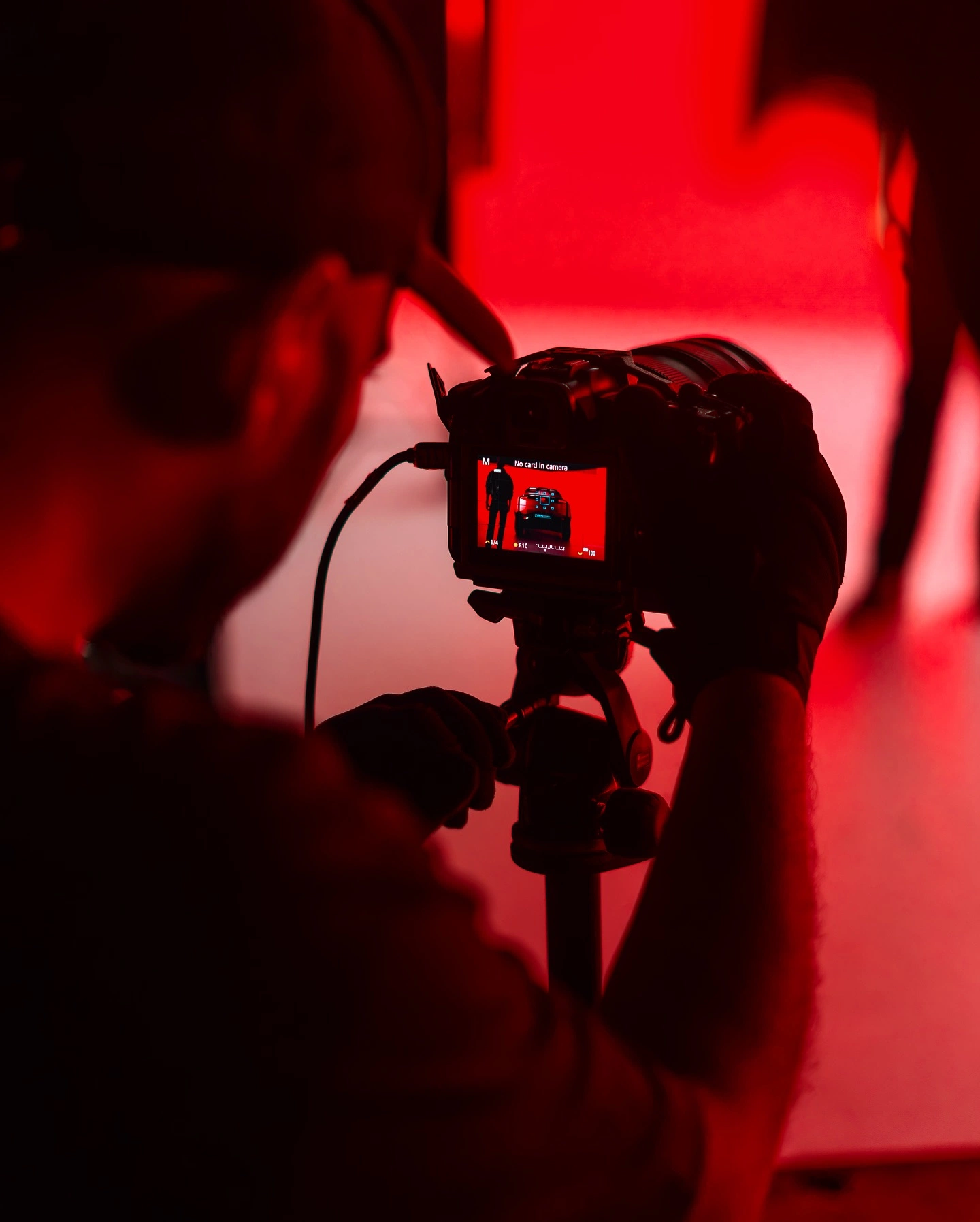 Bastidores de uma produção audiovisual com câmera e iluminação vermelha